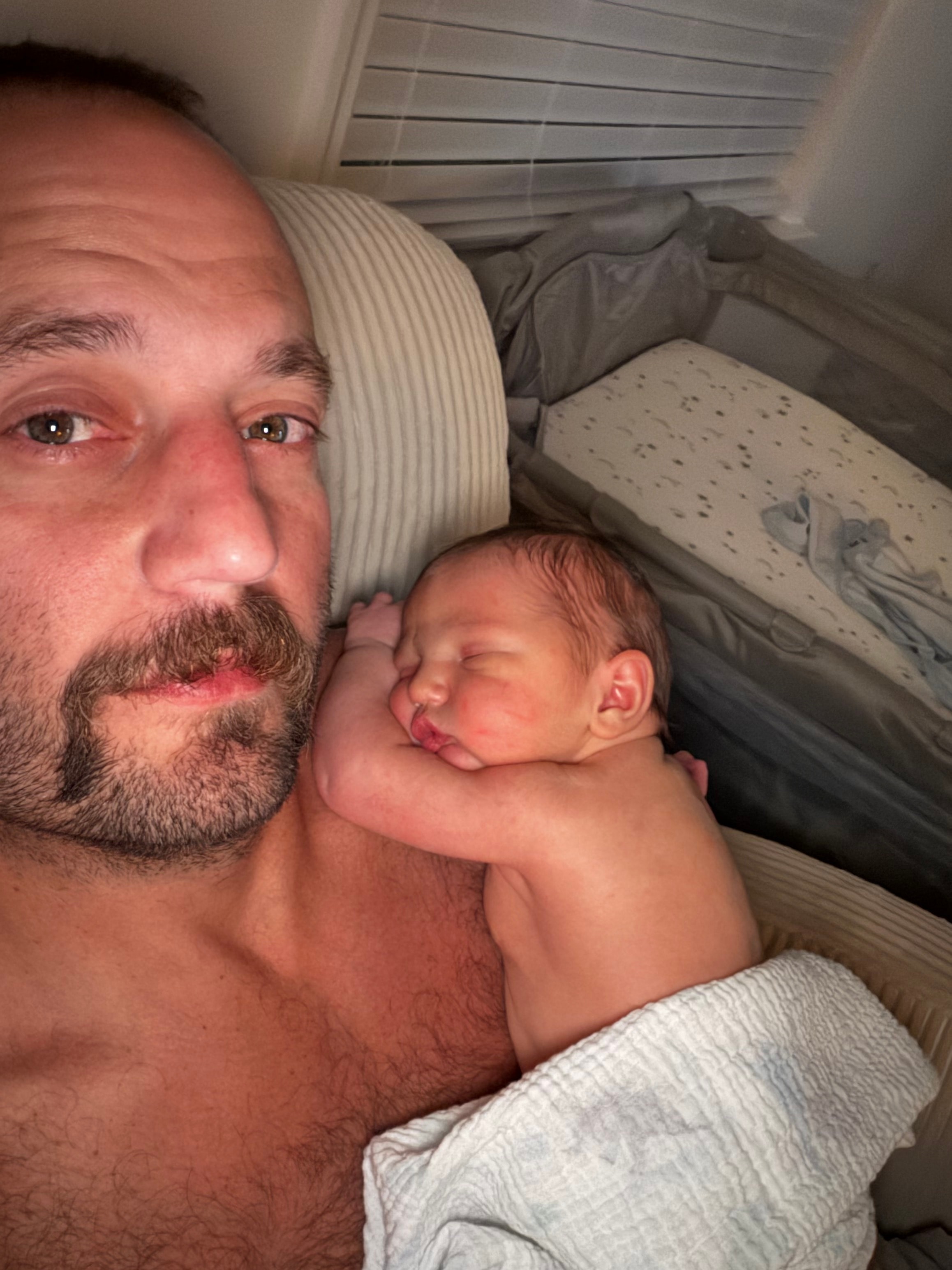Adam Lowery holding his newborn child